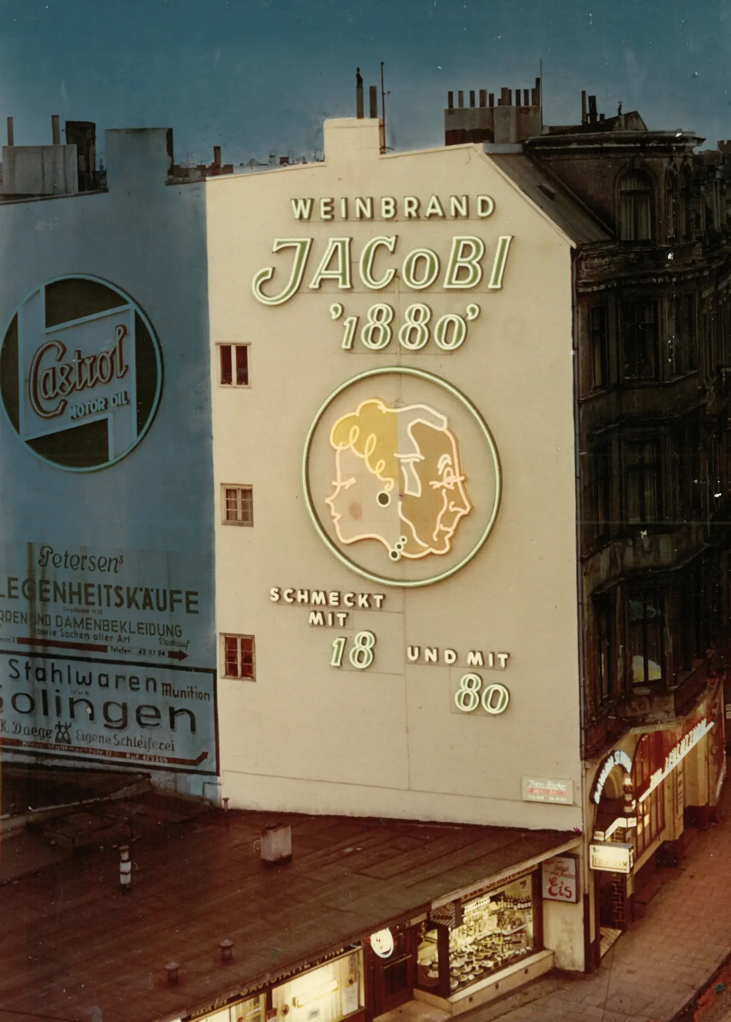 Historic building facade with a large JACoBI 1880 brandy advertisement