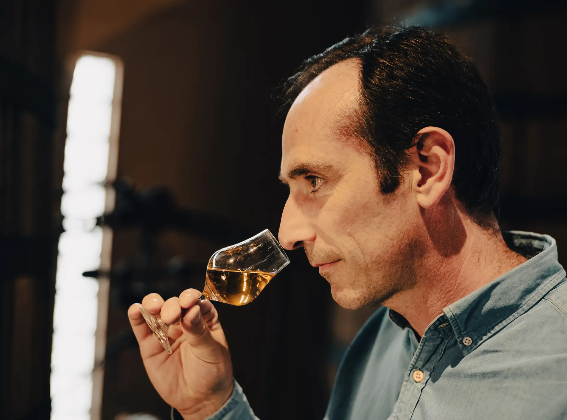 Cellar master nosing a glass of Armagnac