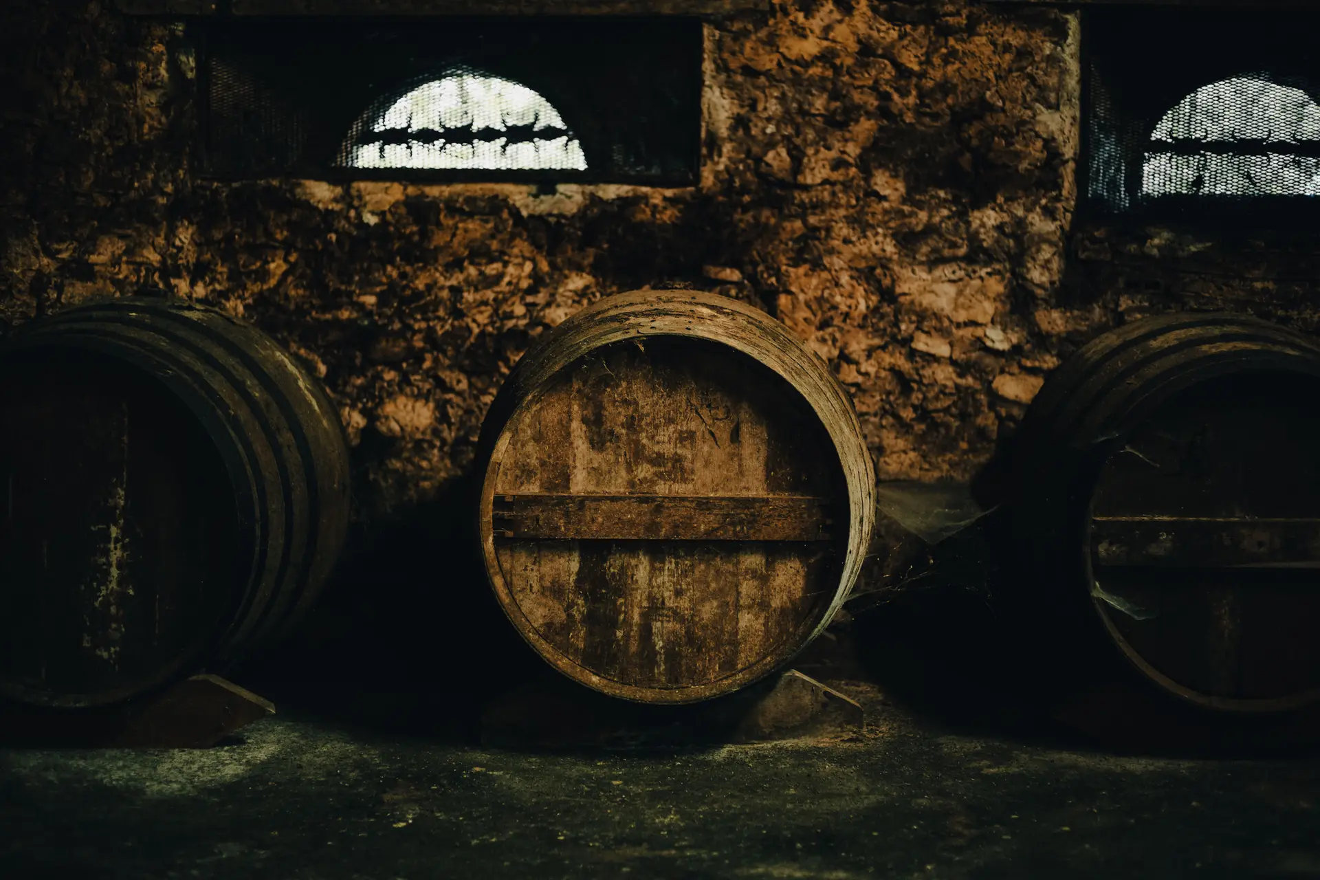 Row of Armagnac casks in the vaulted cellar